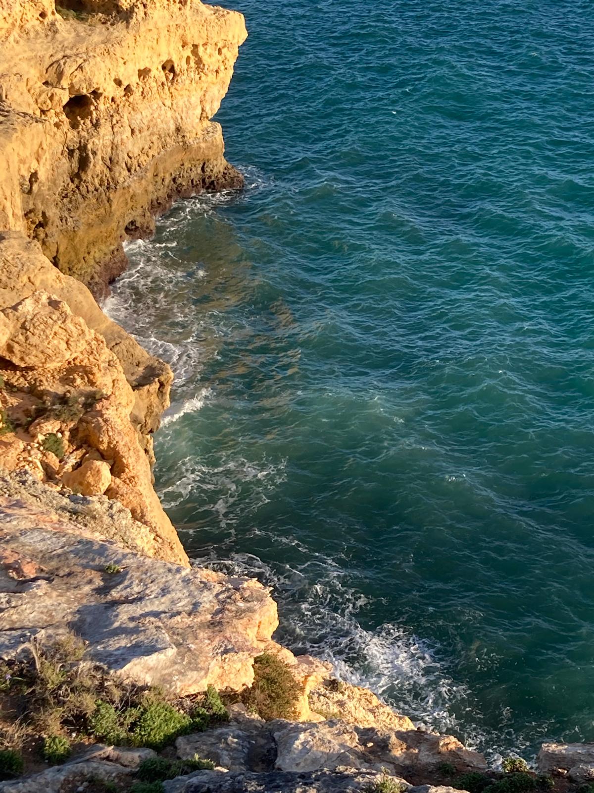 Golden limestone cliffs above the turquoise Atlantic at Algar Seco